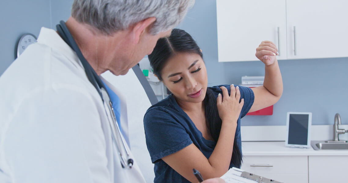 patient showing shoulder pain to doctor